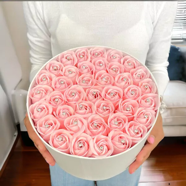 Round white box overflowing with 40 pink artificial roses, each with a diamond accent.