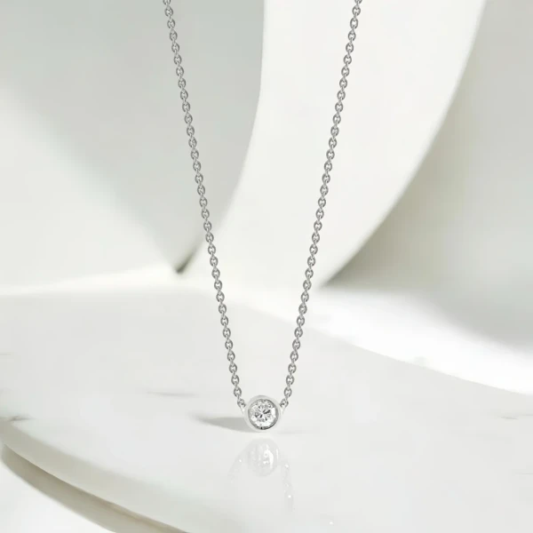 A solitaire moissanite diamond necklace in 18K white gold plating.
