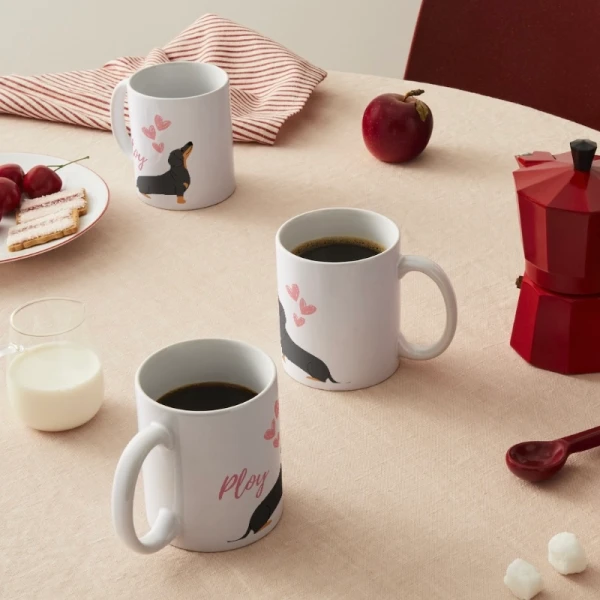 Two white mugs with dachshunds and pink hearts, one with "Ploy" printed on it.