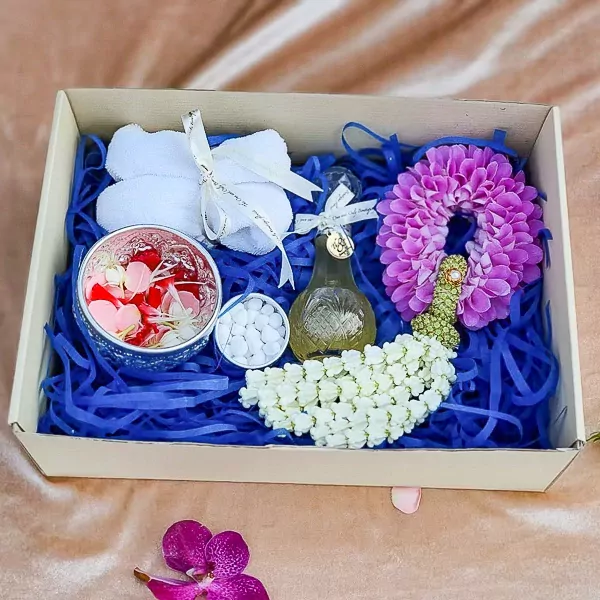 Thai water ceremony gift set with flowers, perfume, and orchids.