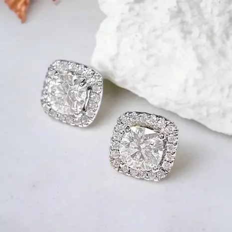 1-Carat cushion-cut moissanite diamond halo stud earrings set in white gold.