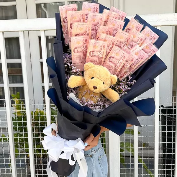 Money bouquet with teddy bear and dried flowers, ready for cash.