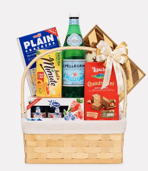 Gift basket with San Pellegrino, crackers, tea, cookies, and jams, tied with a bow.