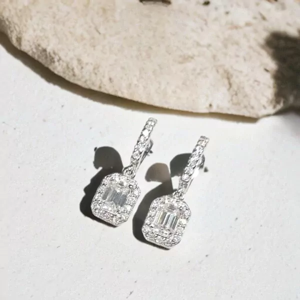 Diamond emerald-cut moissanite drop earrings with pavé diamond halos.