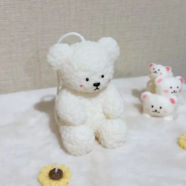 White fluffy bear candle with smaller bears and a sunflower candle.