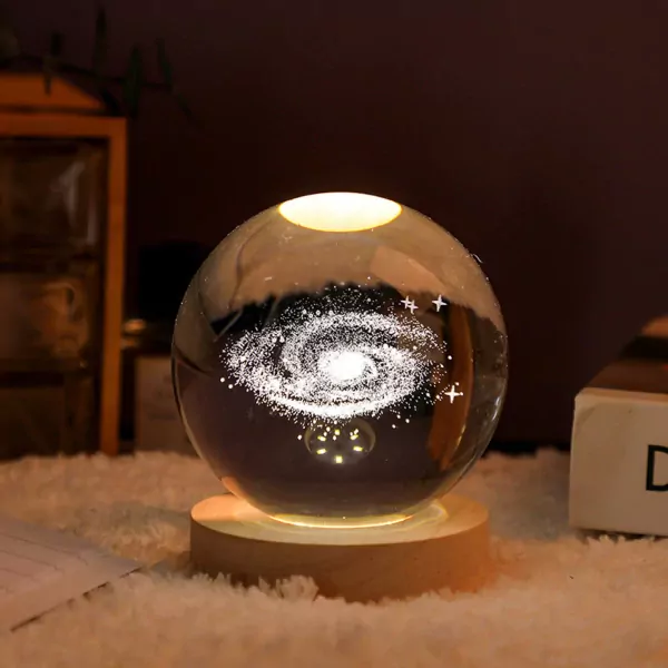 Crystal ball with Milky Way galaxy and stars illuminated from below, on a wooden base.