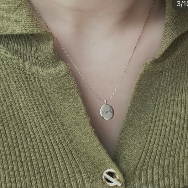Silver oval pendant necklace engraved with "สมาธิ" in Thai script.