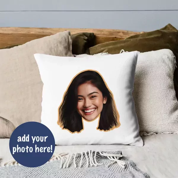 Face pillow with a woman's smiling face on it, surrounded by pillows.