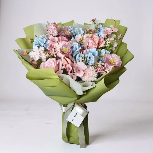 Mix blooms money bouquet with pink and blue artificial flowers wrapped in light green paper.
