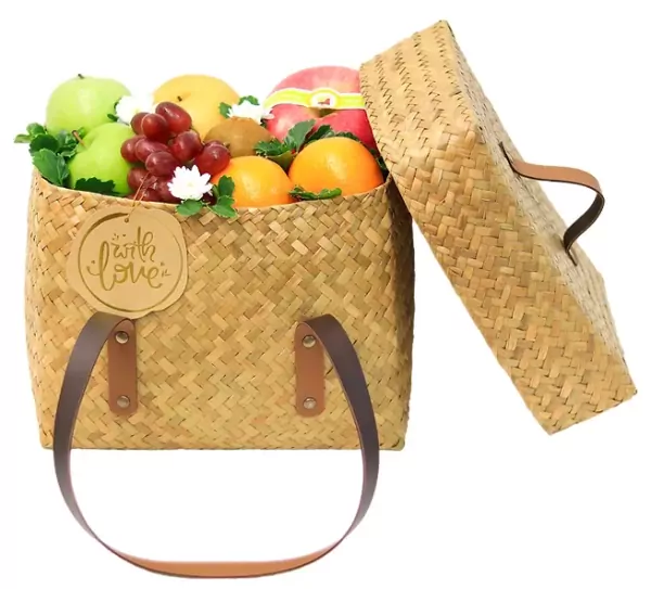 Straw woven fruit basket filled with apples, oranges, grapes, kiwi, and pear, with a "with love" tag.