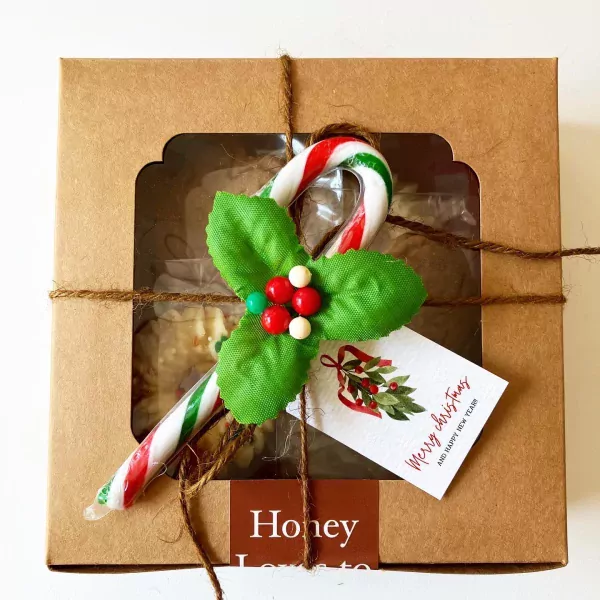 Christmas gift box with candy cane, holly, and "Merry Christmas" tag, containing gingerbread butter cookies.