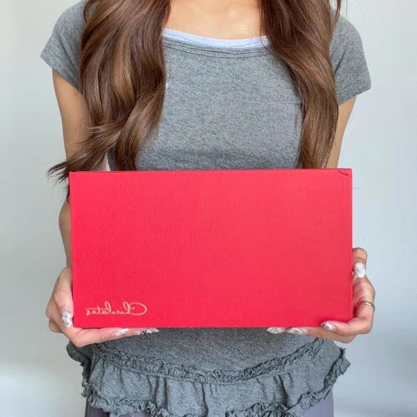 Woman holding a red chocolate box with "Always Yours Chocolate" logo.