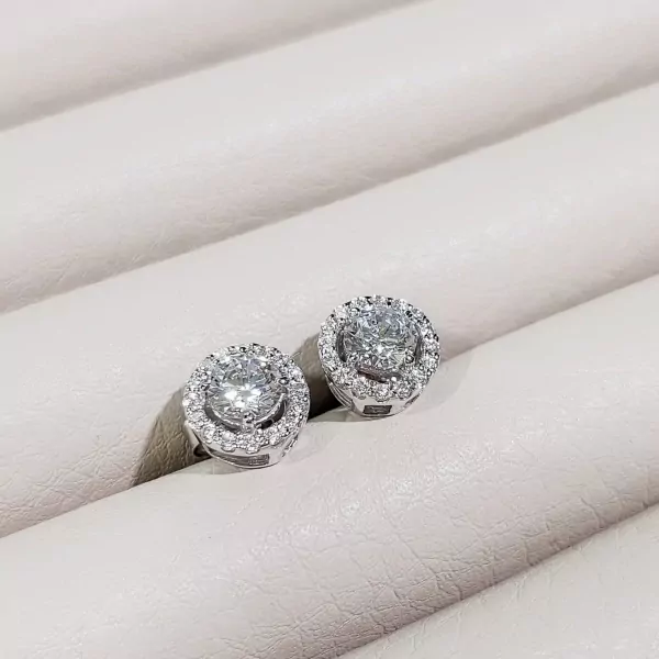 Round-cut moissanite diamond halo stud earrings in white gold.