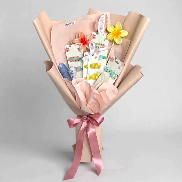 Bouquet of hair clips and faux flowers, wrapped in pink paper and tied with a pink ribbon.