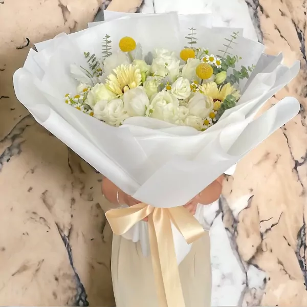 Creamy white roses, gerberas, and yellow craspedia bouquet with daisies, tied with a satin ribbon.