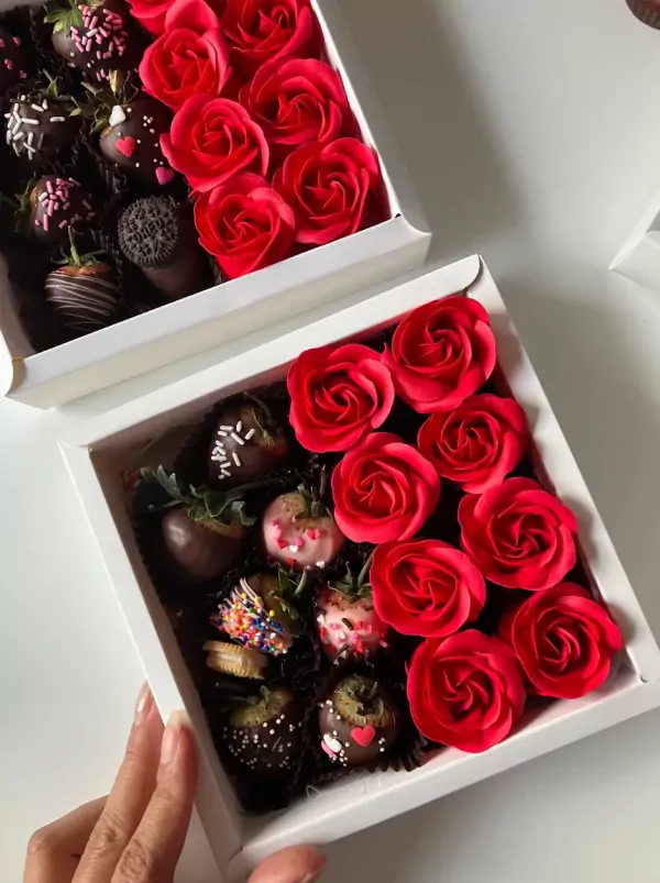 Box of chocolate-covered strawberries and red roses.