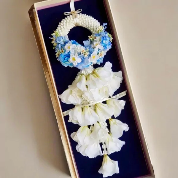 Artificial jasmine and blue flower garland in a gift box.