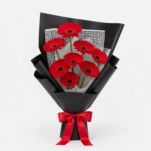 Red gerbera daisy bouquet wrapped in black paper with a red ribbon.