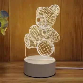 Acrylic teddy bear lamp with heart, illuminating a warm light on a wooden surface.