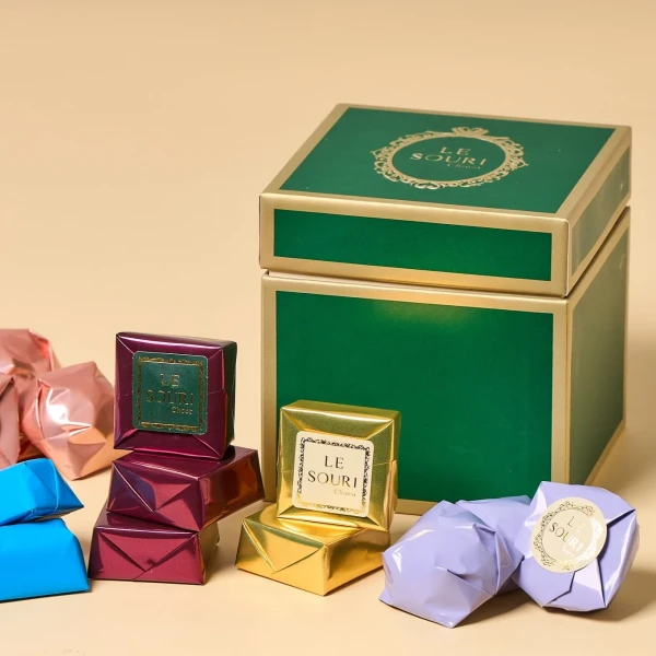 Green and gold Le Souri chocolate gift box with individually wrapped chocolates.