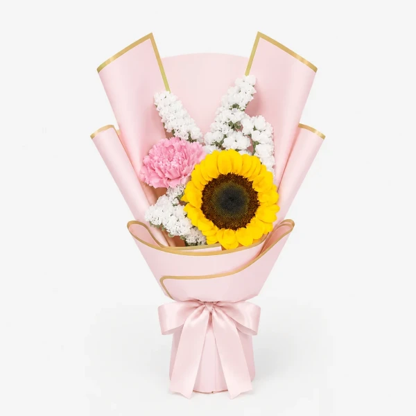 A pink bouquet with a sunflower, carnation, and greenery, tied with a pink ribbon.