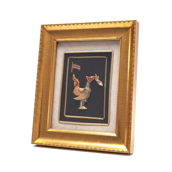 Gold-framed art with a metal Garuda emblem on a black background.