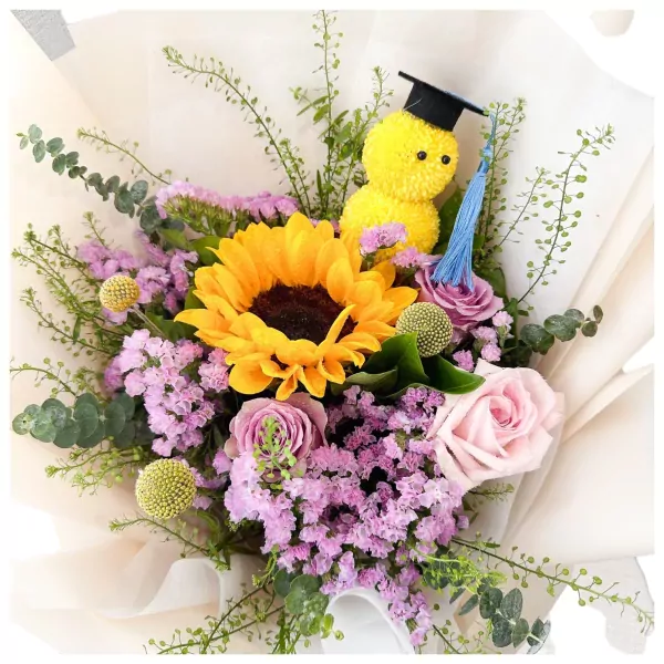 Graduation bouquet with yellow sunflower, pink roses, and a graduation-hat-wearing duck plushie.