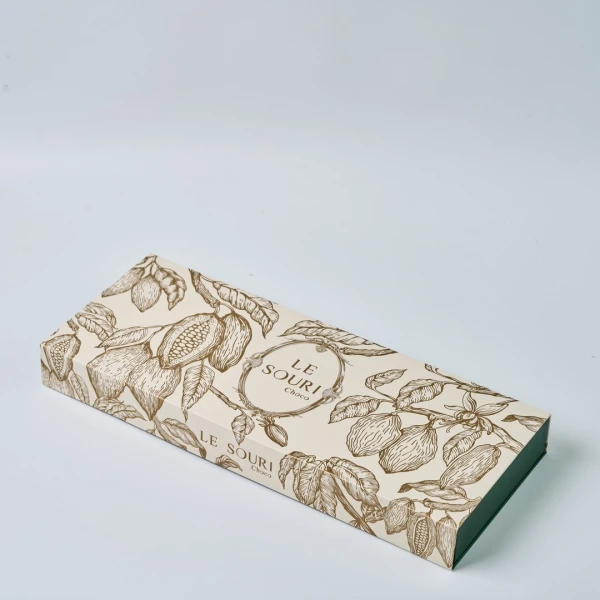 Le Souri Signature Chocolate Box with cocoa tree illustration on a light background.