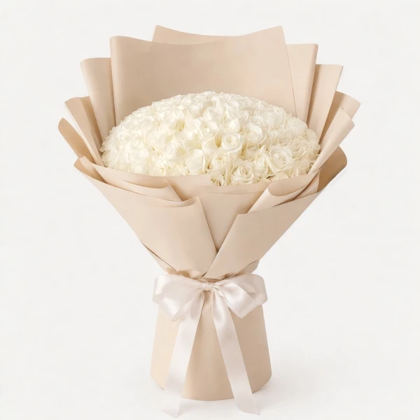 A large bouquet of 100 white roses wrapped in white paper with a hint of pink ribbon.