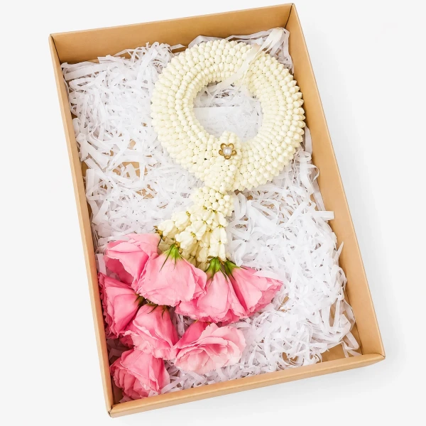 A white jasmine garland with pink roses in a gift box.
