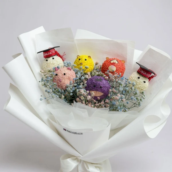 Graduation bouquet of colorful pom-pom "flowers" in graduation caps, surrounded by baby's breath.