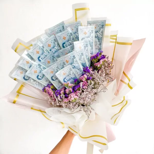 A money bouquet with 50-unit banknotes and dried purple and pink flowers.