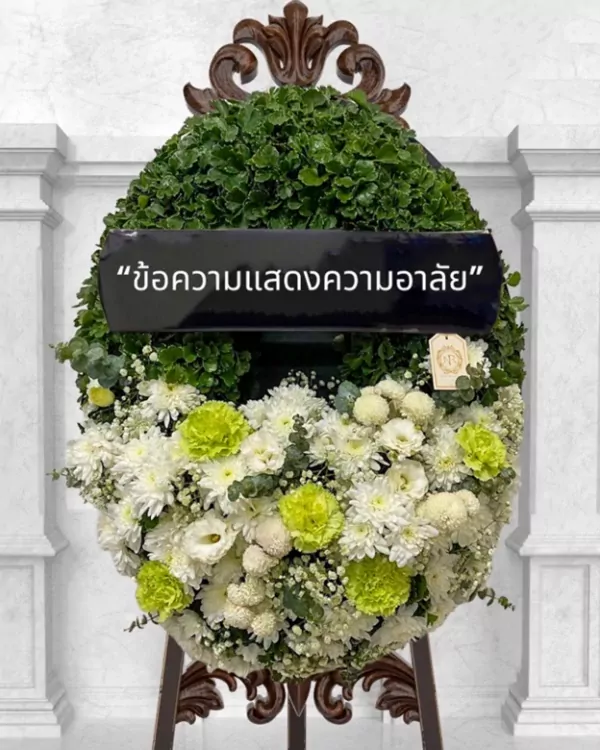 A large, oval wreath of green foliage and white and green flowers with a black banner saying "ข้อความแสดงความอาลัย".