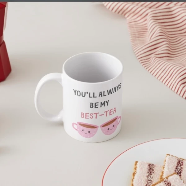 White mug with "you'll always be my best-tea" and two smiling teacups.