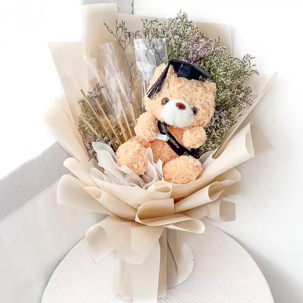 Graduation teddy bear bouquet with diploma and cap, wrapped in neutral paper.