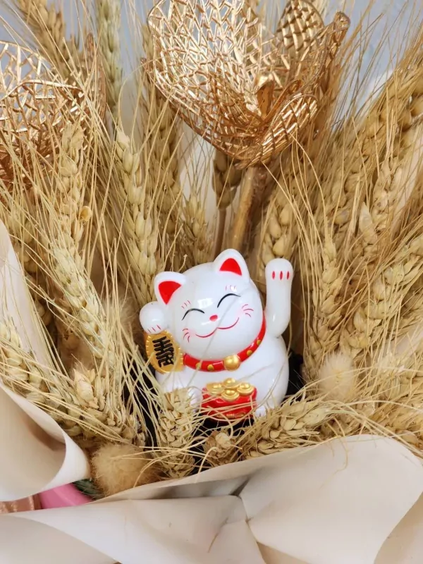 Maneki-Neko cat with gold accents and wheat stalks in a pink hatbox.