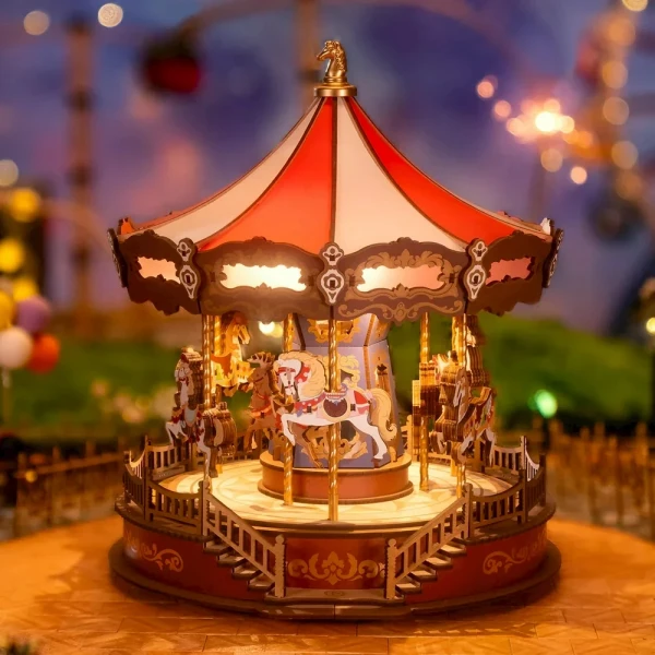 A miniature wooden carousel with red and white striped canopy, detailed horses, and intricate railings, lit from within.