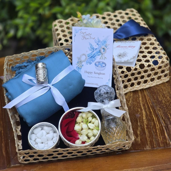 Songkran gift basket: blue scarf, Som Hand inhaler, flower bowls, glass bottle, and cards.