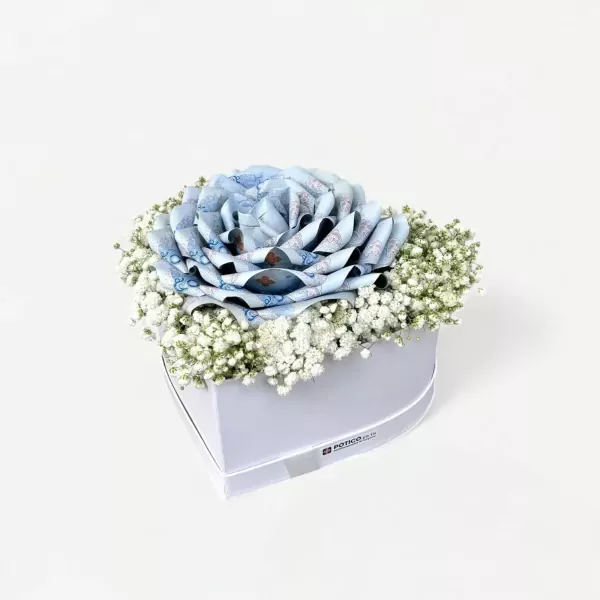 Heart-shaped box with a blue rose made of money and white baby's breath flowers.