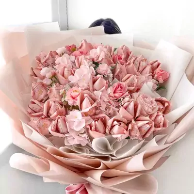 Pink money bouquet with artificial flowers, a creative gift.