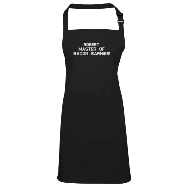 Black apron with "ROBERT MASTER OF BACON SARNIES!" embroidered in white text.
