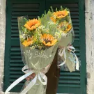 Bouquet of sunflowers with "Happy Graduation My Sister" written on the wrapping.