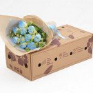 Bouquet of blue roses and daisies in a cardboard box.