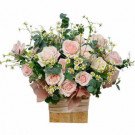 Pink roses and chamomile in a wooden box with a pink ribbon.