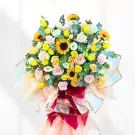 Large floral arrangement with sunflowers, roses, and greenery in a decorative stand.