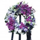 Purple and white floral wreath with orchids on a black easel.