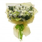 Bouquet of white roses, greenery, and baby's breath, wrapped in pale yellow paper and tied with a green ribbon.