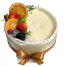 Sunny Corn Mousse Cake with fresh fruits and a golden bow.