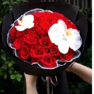Bouquet of 40 red roses and white orchids in black paper wrapping.