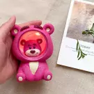 Pink Lotso bear night light with red lights inside, held by a hand.